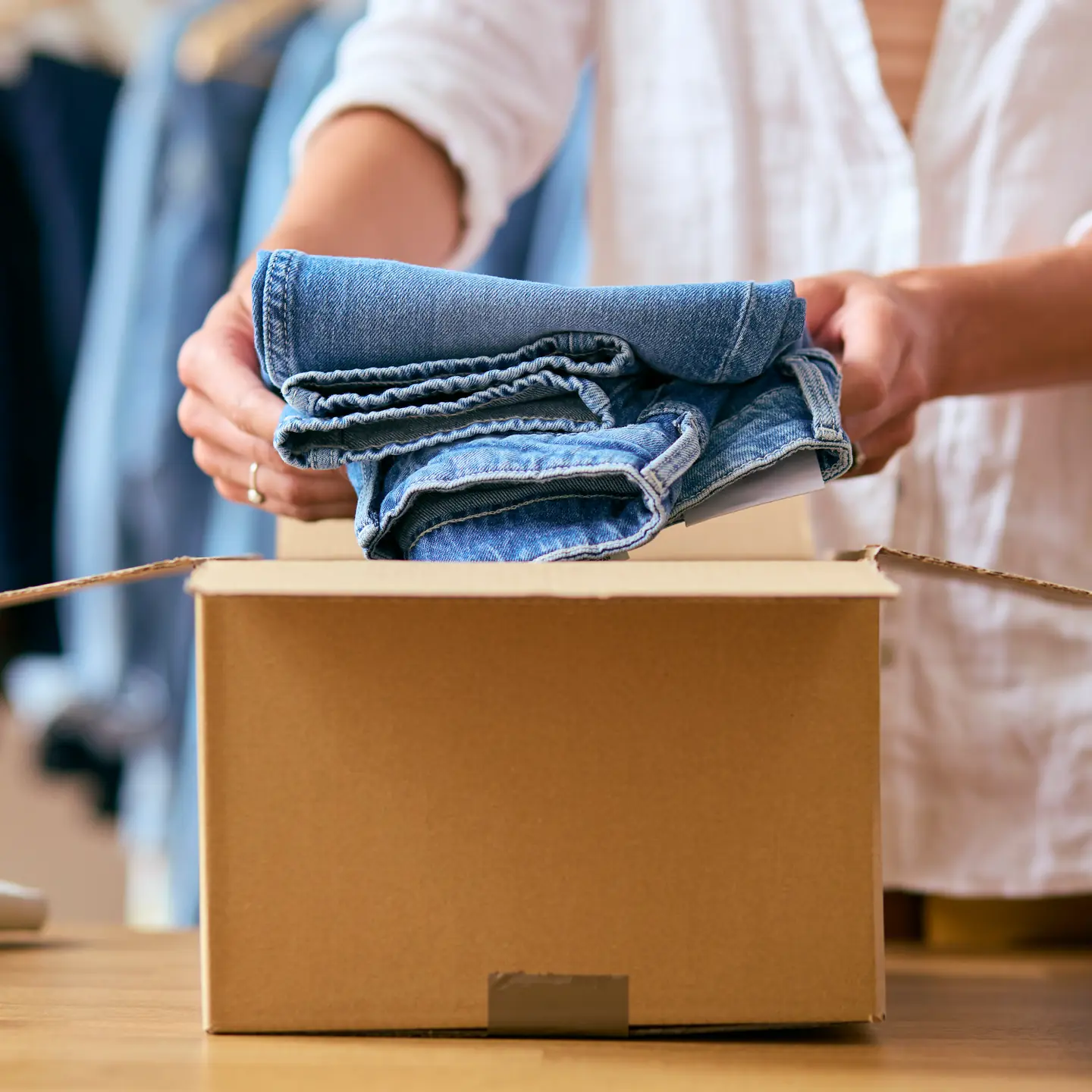 Student-packing-extra-clothing-into-a-box-for-term-time-storage.webp