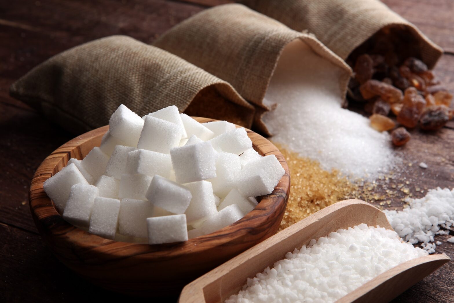 Various types of sugar, brown sugar and white on wooden table