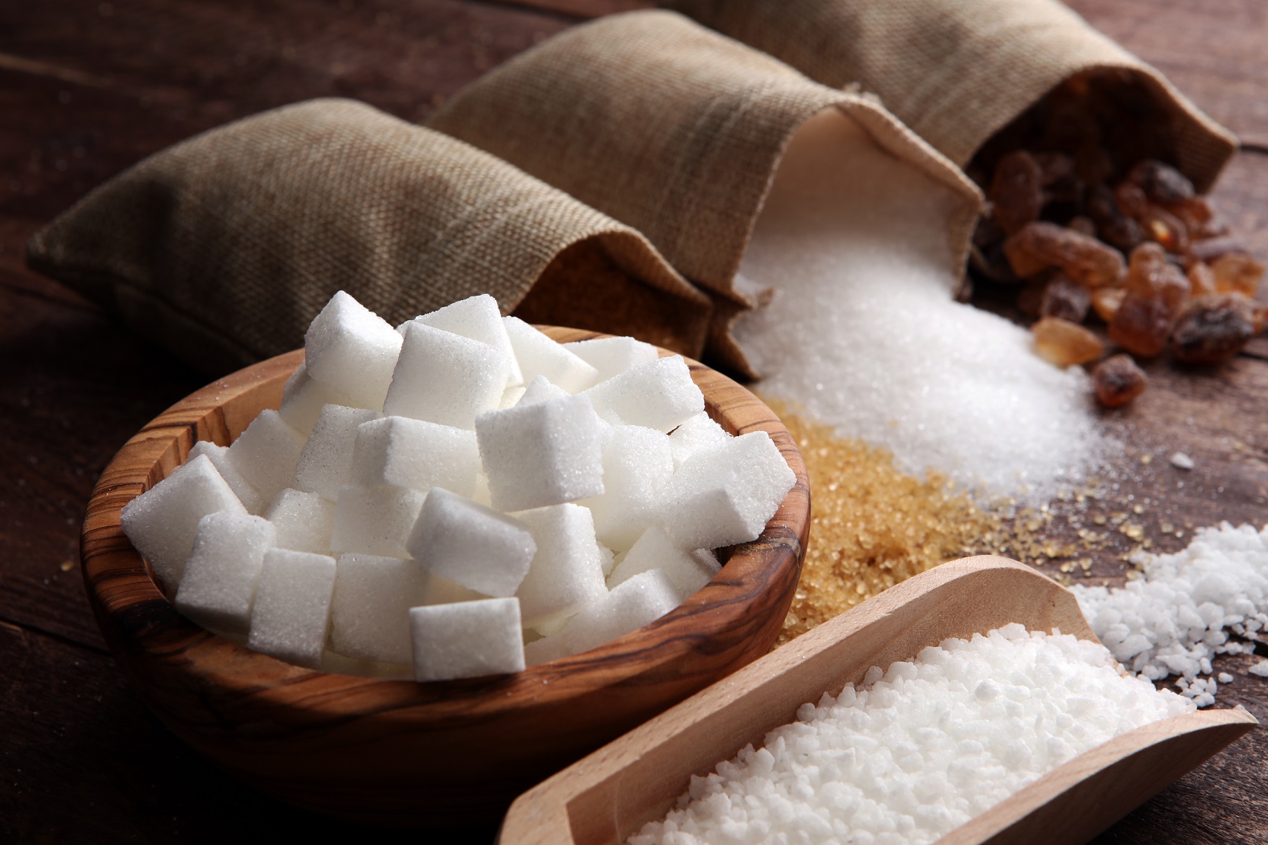 Various types of sugar, brown sugar and white on wooden table